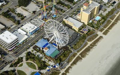 Aerial View of the oceanfront Skywheel, Pier and Boardwalk, restaurants, condominiums, resorts and hotels along the Grand Strand of Myrtle Beach, South Carolina. All logos have been removed.