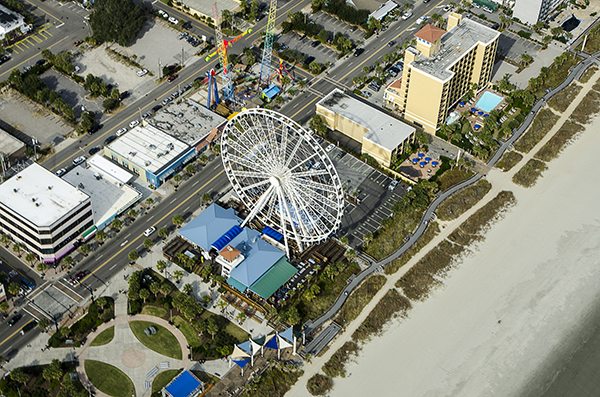 Aerial View of the oceanfront Skywheel, Pier and Boardwalk, restaurants, condominiums, resorts and hotels along the Grand Strand of Myrtle Beach, South Carolina. All logos have been removed.