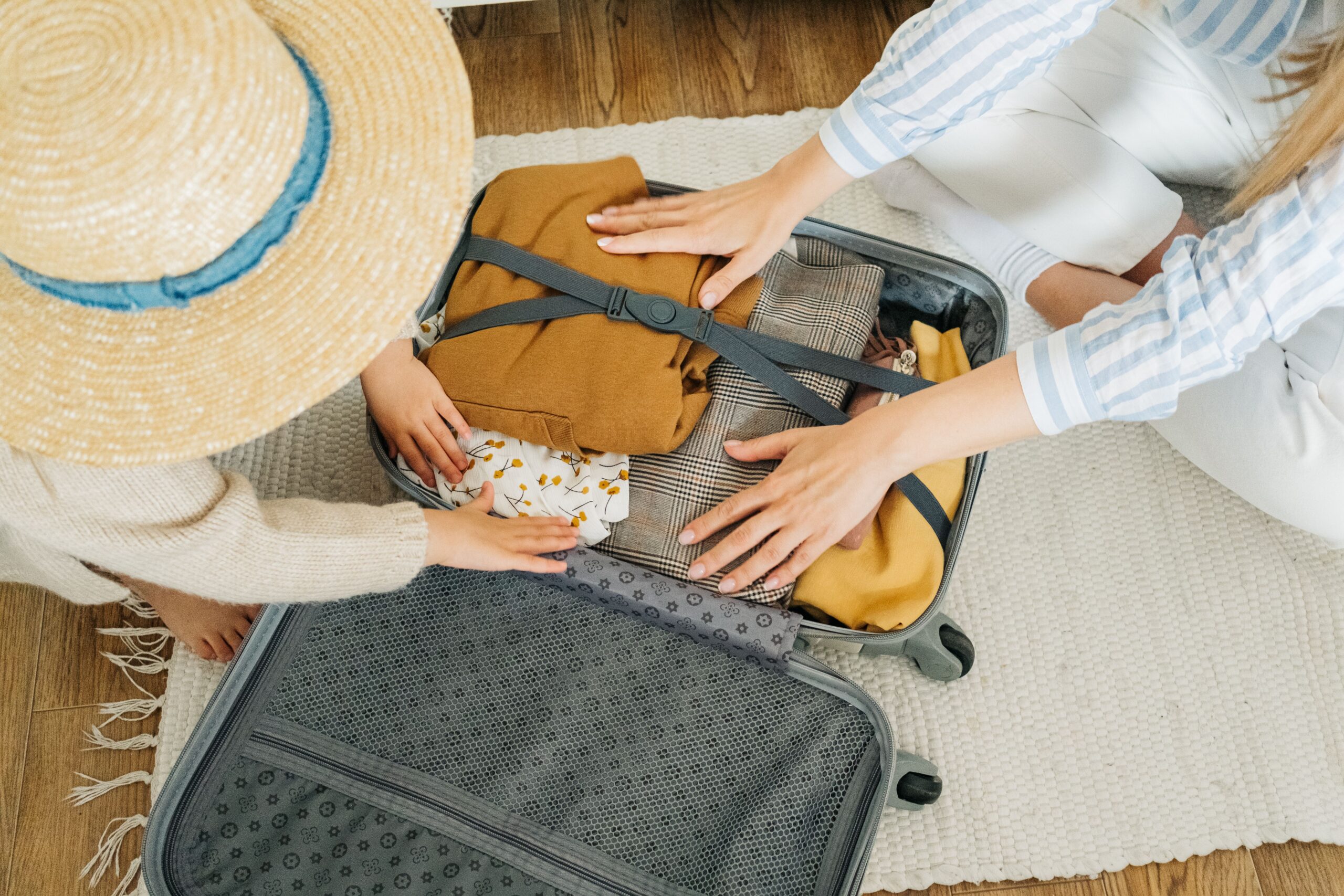 mother and daughter packing a suitcase for an affordable vacation to myrtle beach