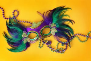 Colorful Mardi Gras mask on a background made with Mardi Gras beads
